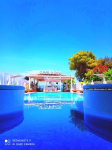 a swimming pool with a gazebo in the background at Cavo D' Oro Complex in Kavos