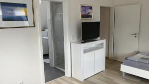 a living room with a tv on a white cabinet at München Waldperlach ruhig und sehr schöne Wohnung in Munich