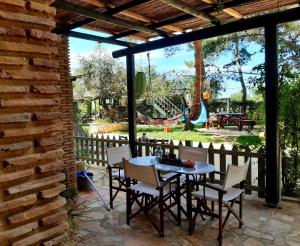 a patio with a table and chairs and a playground at Alegria Villas Complex in Vasilikos