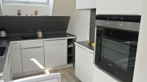 a kitchen with white cabinets and a black oven at München Waldperlach ruhig und sehr schöne Wohnung in Munich