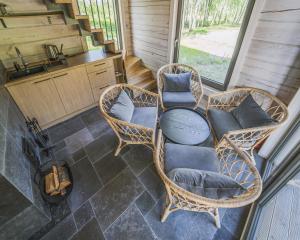 eine Veranda mit Korbstühlen und einem Tisch in der Unterkunft Sodyba Voverė in Inturkė