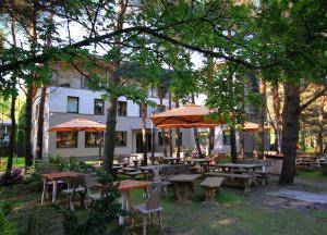 a group of tables and umbrellas in front of a building at Gintarautojai in Palanga