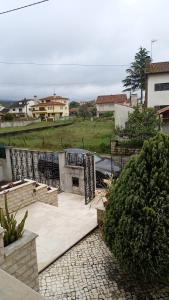ポンバルにあるTelesico Residenciaのグリルと家のあるパティオの景色を望めます。