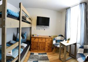Zimmer mit Etagenbetten, einem Schreibtisch und einem TV in der Unterkunft Gasthof zur Linde in Pausa