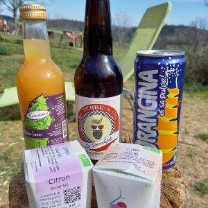 a table with two bottles and a can of beer at Les Soleillas pour votre zen'ittude in Chalencon +45 photos