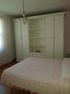 a bedroom with a bed with white cabinets and a chandelier at Relax da Sabry in Senigallia +19 photos