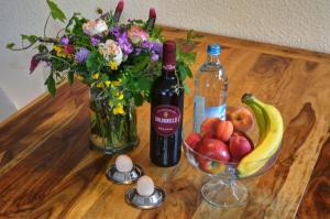 een tafel met een vaas met bloemen en een fles wijn bij Ferienwohnung "Zum Paladin" in Berg