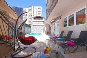 eine Terrasse mit Stühlen und einer Hängematte auf einem Gebäude in der Unterkunft Villa Naomi in Split