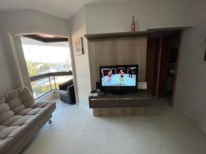 En tv och/eller ett underhållningssystem på Apartamento Florianópolis ponta das canas