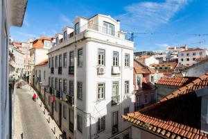 Blick auf ein weißes Gebäude in einer Stadtstraße in der Unterkunft Flat do Chiado 03 in Lissabon