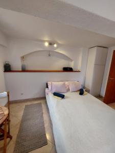 sypialnia z dużym białym łóżkiem z 2 poduszkami w obiekcie Apartments FRAGOLINA w mieście Donje Selo na Šolti