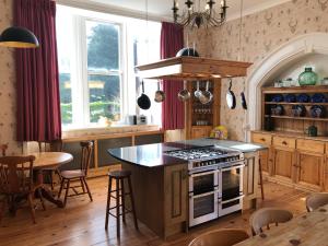 a kitchen with a stove and a table with chairs at Irton Hall in Eskdale