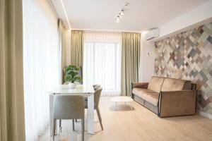 Bel Air Apartments Mamaia Nord في مامايا: غرفة معيشة مع أريكة وطاولة