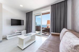 a living room with a couch and a tv at Apartment Tonka in Cavtat