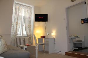 a living room with a bed and a desk and a window at Apartment Vltava Prague in Prague