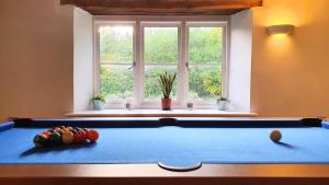 a pool table in a room with a window at Glenfield Cottage - Secluded Luxury deep in the Oxfordshire Countryside in Wilcote