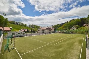 a tennis court in front of a large building at BOUDA MORAVA in Dolni Dvur