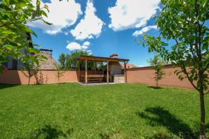 a backyard with a gazebo and a green yard at Vila melek 4 bedrooms in Sarajevo