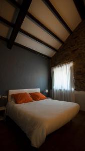 a bedroom with a white bed and a window at Casas do Campo in Monfero