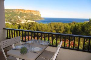 a table on a balcony with a view of the ocean at Vu Mer by K6&You in Cassis