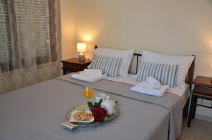 a bedroom with a bed with a tray of food on it at Mani Villas in Skala Sotiros