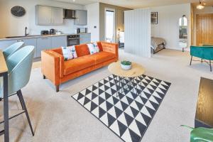a living room with an orange couch and a table at Host & Stay - North Marine House in Scarborough