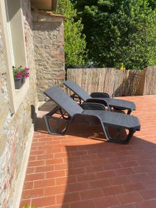 a group of chairs sitting on a brick patio at Tuscan Skye - Caterina Studio Apartment in Barga