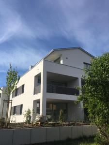 a white building with a fence in front of it at seelandsuite Bodensee in Bermatingen