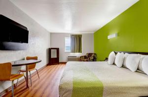 Habitación con cama con pared verde en Motel 6-Moriarty, NM, en Moriarty