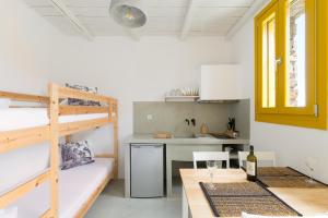 a room with a bunk bed and a table with a wine glass at Themonies Suites and Apartments in Kithnos