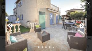 un patio con sedie, tavolo e una casa di Villa Maeva à 300 m des plages a Antibes