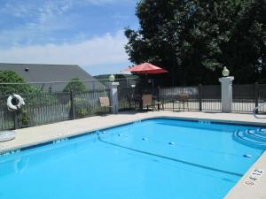 una gran piscina azul junto a una valla en SureStay Plus Hotel by Best Western Asheboro, en Asheboro