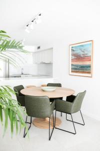 a dining room with a wooden table and chairs at Aqua Linea in Noosa Heads