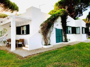 a white house with a table in the yard at GOLF & BEACH VILLA in Vale do Lobo