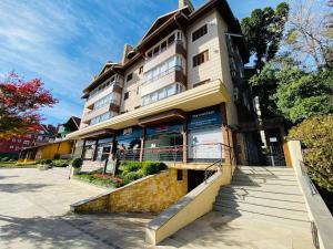 Un gran edificio con una escalera en el frente. en MRG - Completo 2 Suítes a 600m Rua Coberta, en Gramado