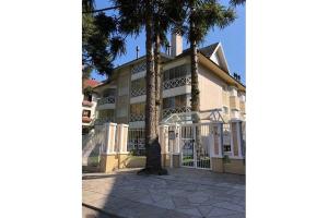 a building with palm trees in front of it at MRG - Ensolarado 2D - Centro de Gramado in Gramado