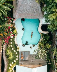 an overhead view of a swimming pool with a house at Kuno Villas in Gili Trawangan