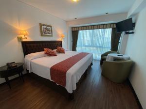 Habitación de hotel con cama y silla en Hotel Monte Real, en Lima