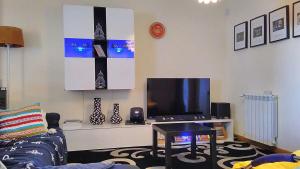 sala de estar con sofá y TV en Oceanview Duplex shared Pool & Beach Sesimbra, en Sesimbra