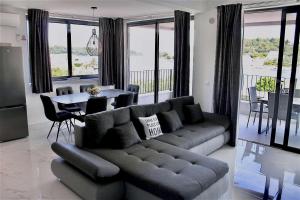 ein Wohnzimmer mit einem Sofa und einem Tisch in der Unterkunft Apartments Marebella in Lumbarda
