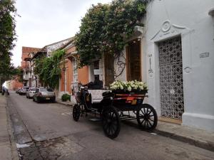 un carruaje tirado por caballos estacionado al lado de una calle en Casa Abril II, en Cartagena de Indias