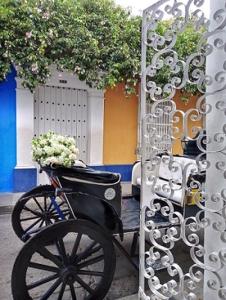 Una bicicleta con flores en una cesta junto a una puerta en Casa Abril II, en Cartagena de Indias