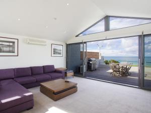 a living room with a purple couch and a view of the ocean at One 36 in Lorne