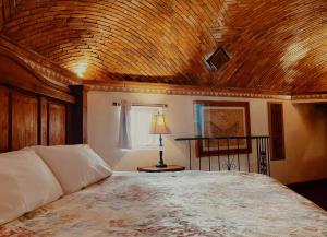 a bedroom with a bed with a wooden ceiling at Casa de Pita in Guanajuato