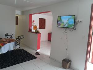 uma sala de estar com uma televisão na parede em Divima em Sainte-Anne