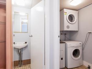 a bathroom with a washing machine and a sink at The Commodore, 23,9-11 Donald Street - Delightful unit with gorgeous water views, air con and wi-fi in Nelson Bay