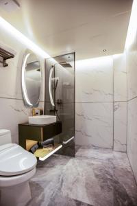 y baño con aseo, lavabo y espejo. en Amber Hotel Jeju, en Jeju