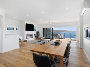 a dining room and living room with a table and chairs at Oceania 1 in Lorne