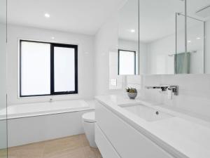 ein weißes Badezimmer mit Toilette und Waschbecken in der Unterkunft Oceania 1 in Lorne + 10 Fotos