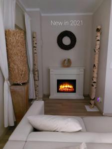 a living room with a fireplace and a white couch at Haus am See in Storkow